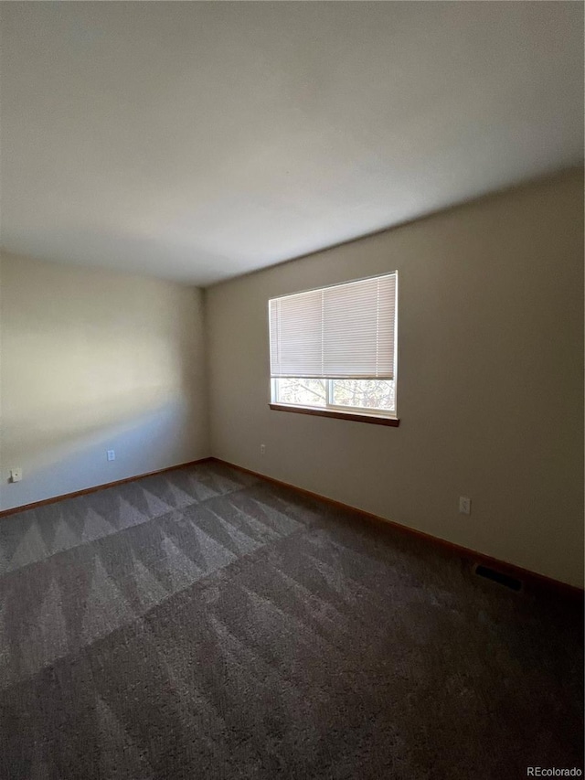 carpeted spare room with baseboards
