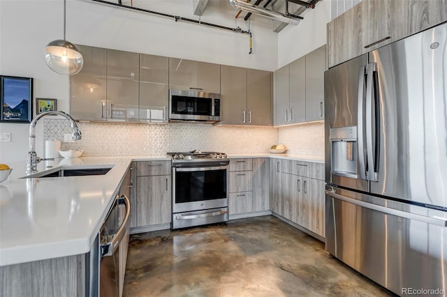 kitchen with backsplash, pendant lighting, gray cabinets, stainless steel appliances, and sink