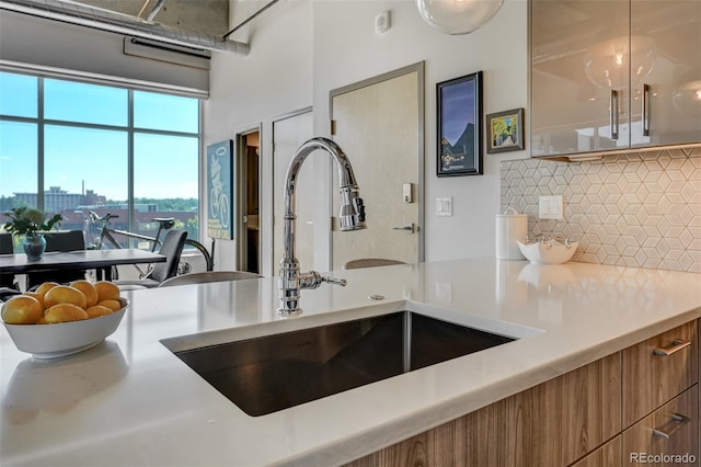 kitchen featuring backsplash, a chandelier, and sink