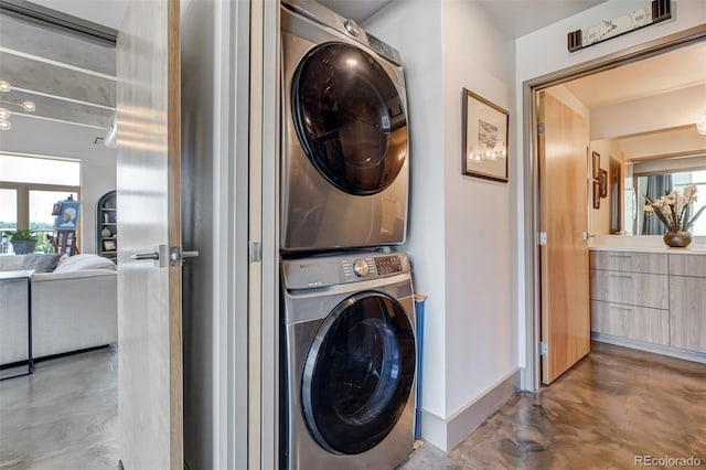 clothes washing area with stacked washer / dryer