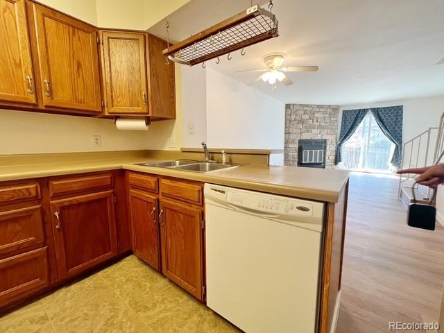 kitchen featuring dishwasher, open floor plan, ceiling fan, a peninsula, and brown cabinetry