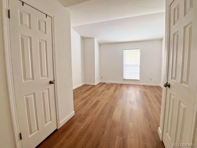 spare room featuring light wood-type flooring and baseboards