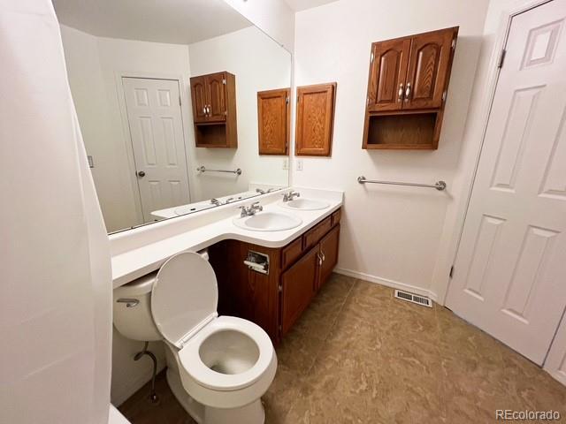 bathroom featuring vanity, baseboards, tile patterned flooring, and visible vents