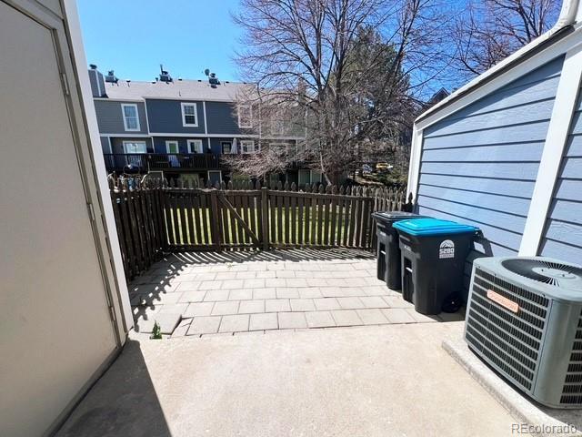 view of patio with cooling unit and fence
