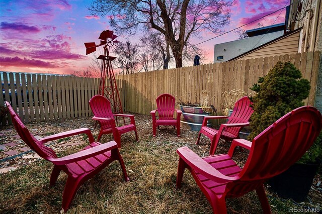 patio terrace at dusk with a fenced backyard