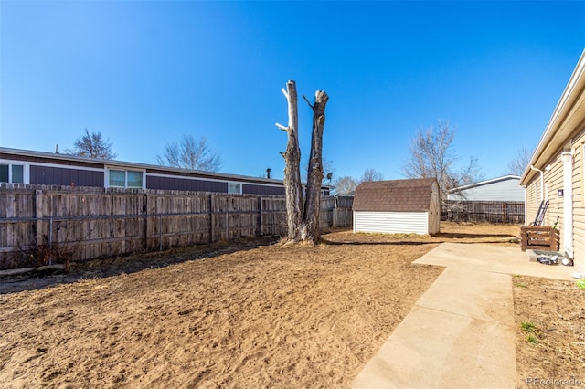 view of yard with a fenced backyard, a shed, and an outdoor structure