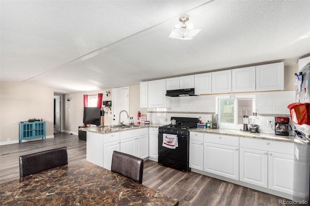 kitchen with dark wood finished floors, black gas range oven, a peninsula, range hood, and white cabinetry