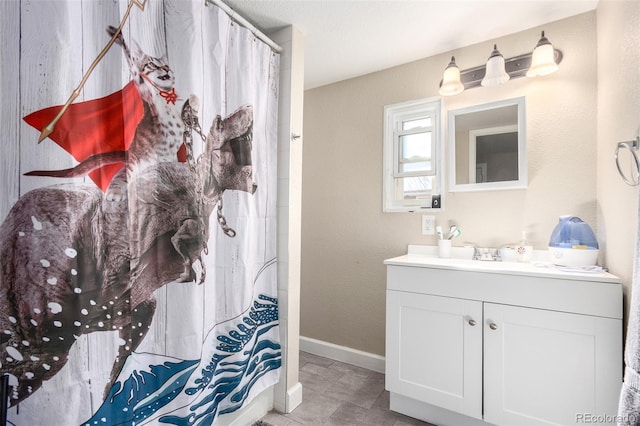 full bathroom with a shower with curtain, vanity, and baseboards