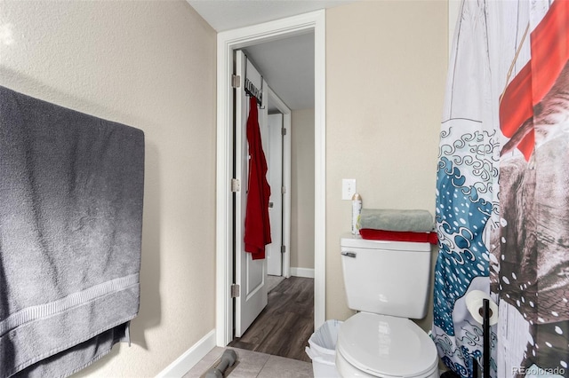 bathroom with baseboards and toilet