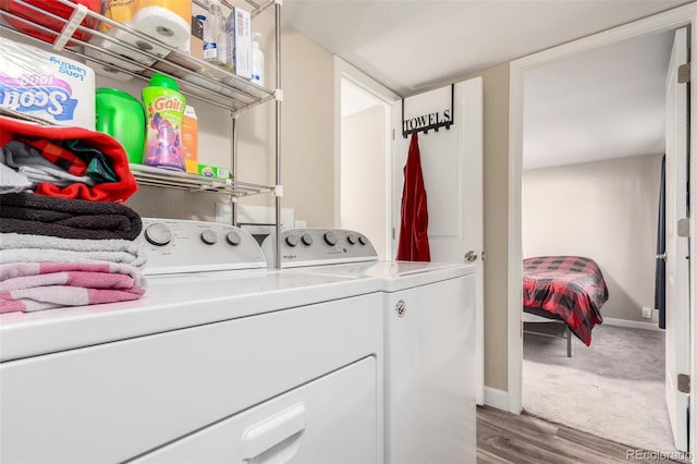 laundry room featuring washer and clothes dryer, wood finished floors, and baseboards