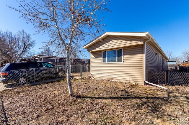 view of side of home featuring crawl space and fence