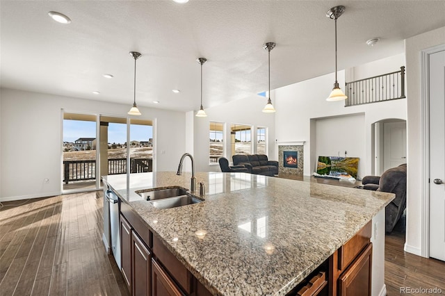 kitchen featuring dark hardwood / wood-style floors, decorative light fixtures, light stone countertops, and sink