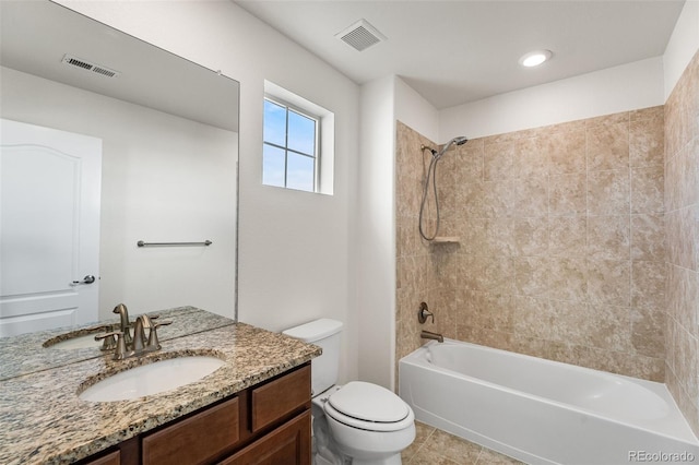 full bathroom with tiled shower / bath, vanity, toilet, and tile patterned floors