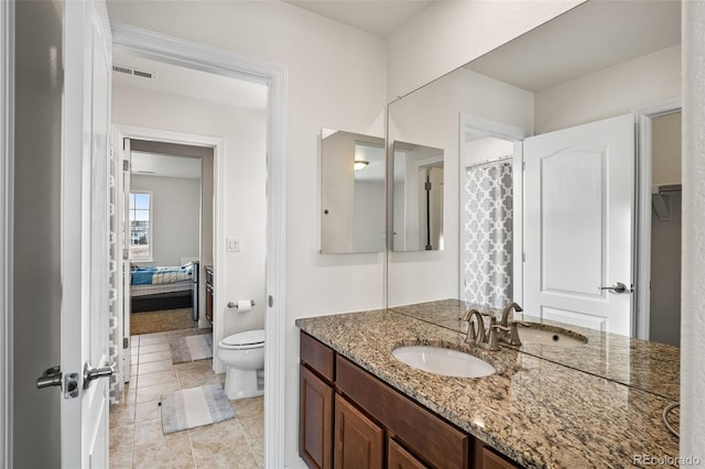 bathroom featuring vanity, toilet, and tile patterned flooring