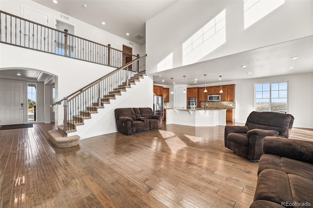 living room with wood-type flooring and a high ceiling