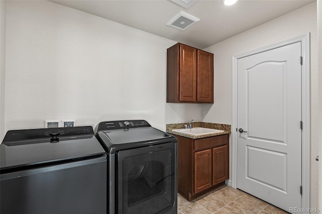 laundry area featuring cabinets, washer and clothes dryer, sink, and light tile patterned floors