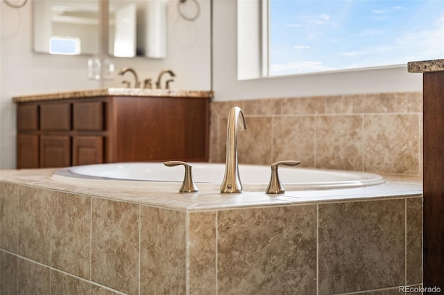 bathroom featuring a relaxing tiled tub and sink