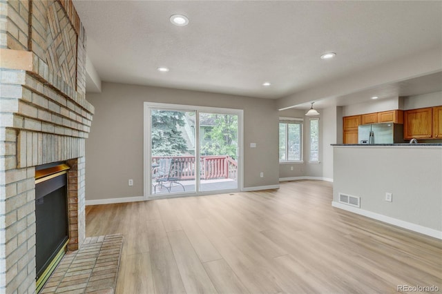 6735 W 97th Cir, Westminster, CO 80021 - unfurnished living room with a fireplace, baseboards, light wood-style floors, and recessed lighting