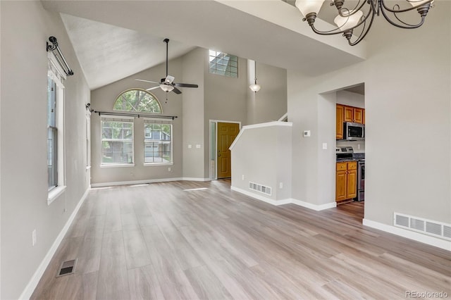 6735 W 97th Cir, Westminster, CO 80021 - unfurnished living room featuring light wood finished floors, a chandelier, high vaulted ceiling, and baseboards