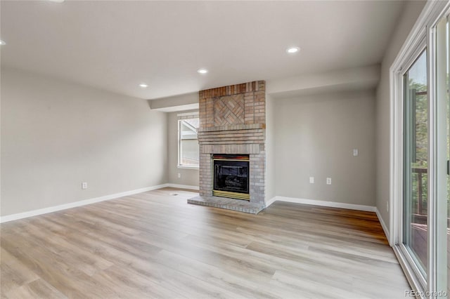 6735 W 97th Cir, Westminster, CO 80021 - unfurnished living room featuring a brick fireplace, light wood-type flooring, baseboards, and recessed lighting