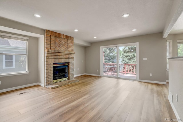 6735 W 97th Cir, Westminster, CO 80021 - unfurnished living room with light wood-style flooring, a fireplace, recessed lighting, and baseboards