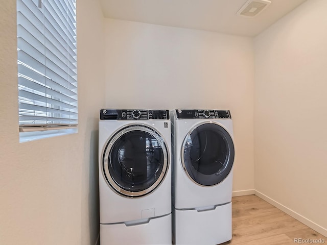 washroom featuring separate washer and dryer and light wood-type flooring