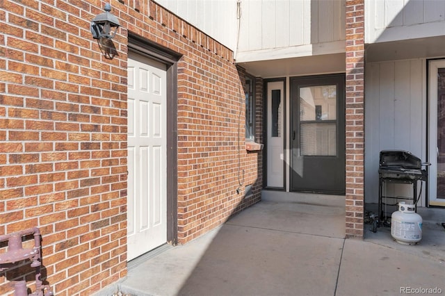 doorway to property featuring brick siding