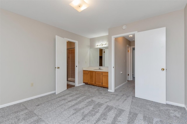 unfurnished bedroom featuring ensuite bath and light colored carpet