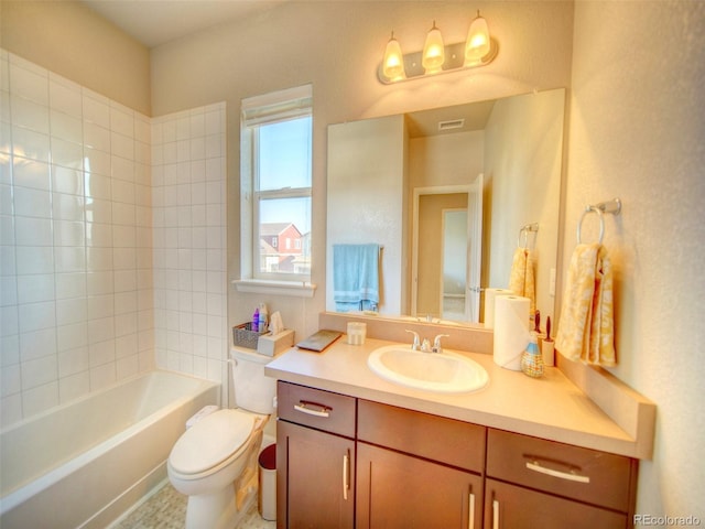 full bathroom with vanity, tiled shower / bath combo, and toilet