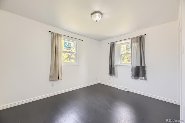 10633 E 6th Pl, Aurora, CO 80010 - empty room featuring plenty of natural light, baseboards, and dark wood finished floors