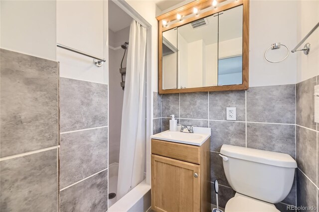 10633 E 6th Pl, Aurora, CO 80010 - full bath featuring tile walls, toilet, vanity, and a shower with curtain