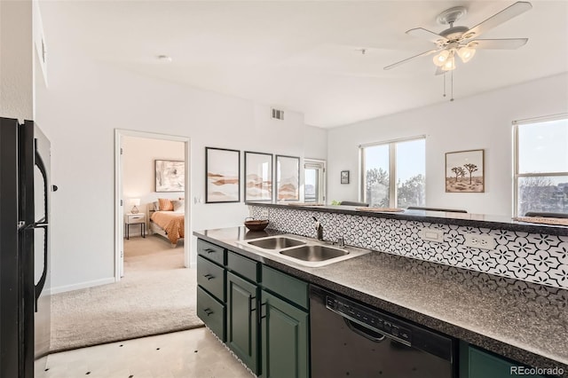 kitchen featuring visible vents, dark countertops, a sink, green cabinets, and black appliances
