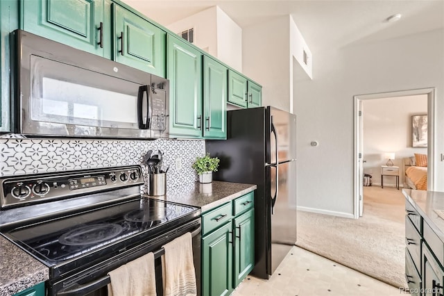 kitchen with light colored carpet, black microwave, stainless steel electric stove, and green cabinets