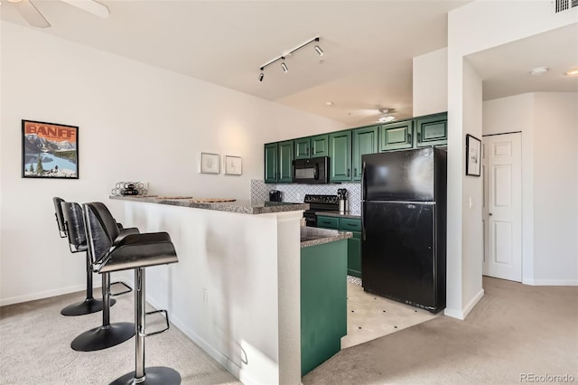 kitchen with a ceiling fan, green cabinets, black appliances, and light carpet