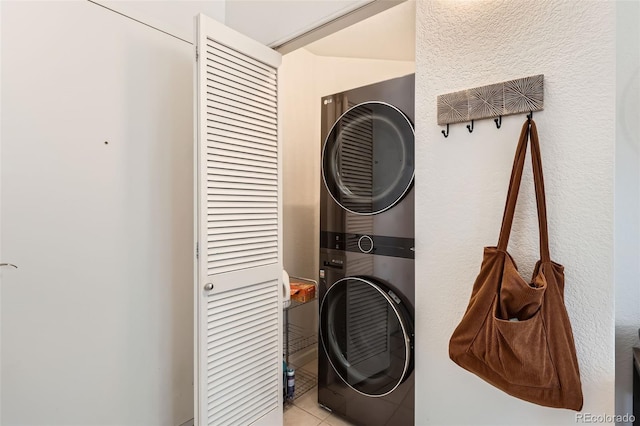 washroom with laundry area, stacked washer and clothes dryer, and light tile patterned flooring