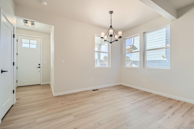 unfurnished dining area featuring light hardwood / wood-style floors, beam ceiling, and a chandelier