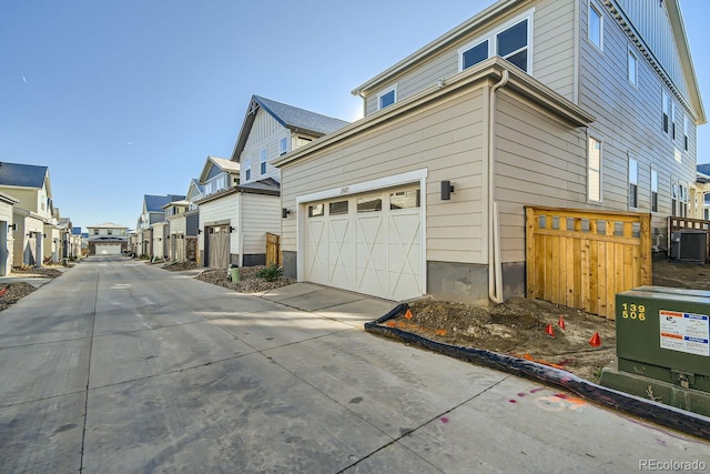 view of side of property with central air condition unit and a garage