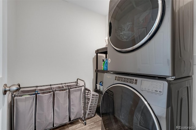 laundry room with light hardwood / wood-style floors and stacked washer / drying machine