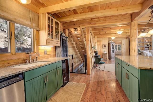 kitchen with green cabinetry, light wood-type flooring, sink, stainless steel dishwasher, and beamed ceiling