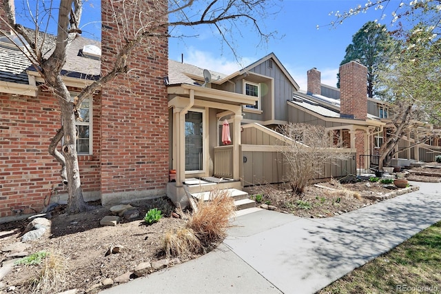 7707 S Curtice Way Unit D, Littleton, CO 80120 - view of front of property featuring a chimney, board and batten siding, and brick siding