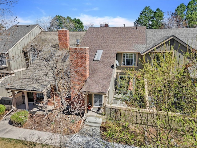 7707 S Curtice Way Unit D, Littleton, CO 80120 - view of front of house featuring a patio, a chimney, roof with shingles, and a garage