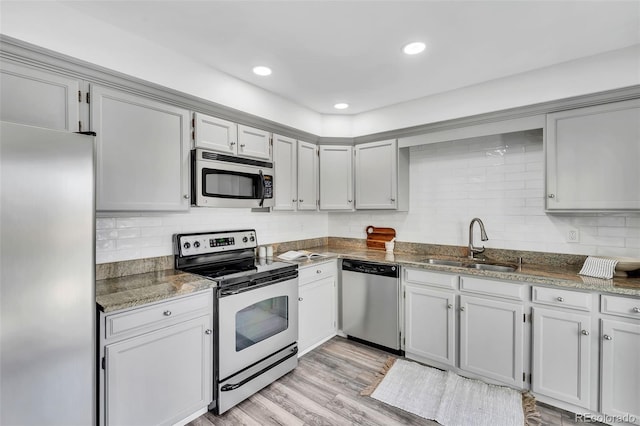 7707 S Curtice Way Unit D, Littleton, CO 80120 - kitchen with stainless steel appliances, a sink, decorative backsplash, and dark stone countertops
