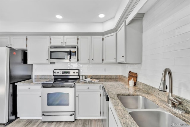 7707 S Curtice Way Unit D, Littleton, CO 80120 - kitchen with appliances with stainless steel finishes, a sink, decorative backsplash, light stone counters, and recessed lighting
