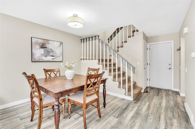 7707 S Curtice Way Unit D, Littleton, CO 80120 - dining space featuring light wood-style floors, stairway, and baseboards