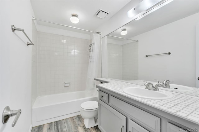 7707 S Curtice Way Unit D, Littleton, CO 80120 - full bath with vanity, shower / bath combo with shower curtain, wood finished floors, and toilet