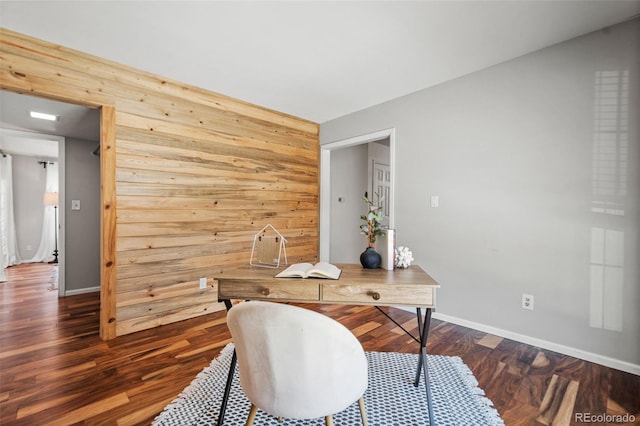 home office with dark hardwood / wood-style flooring and wooden walls