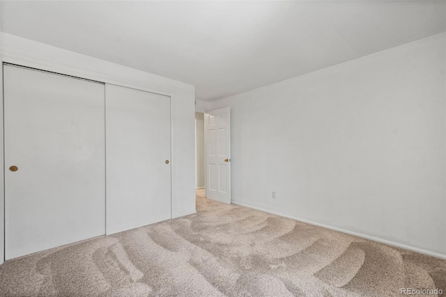 unfurnished bedroom with a closet and carpet flooring