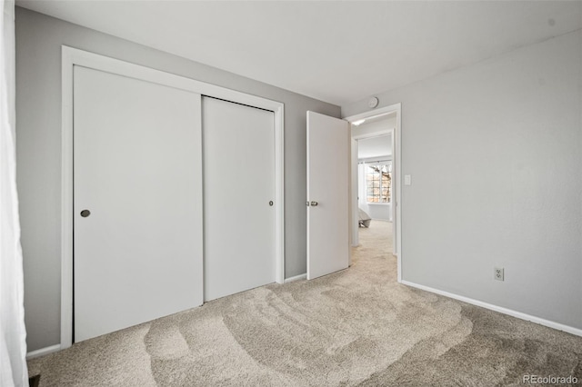 unfurnished bedroom featuring carpet and a closet