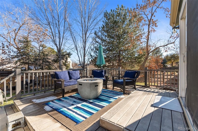 deck with an outdoor living space with a fire pit