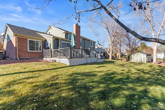 back of property with a deck, a yard, and a storage unit